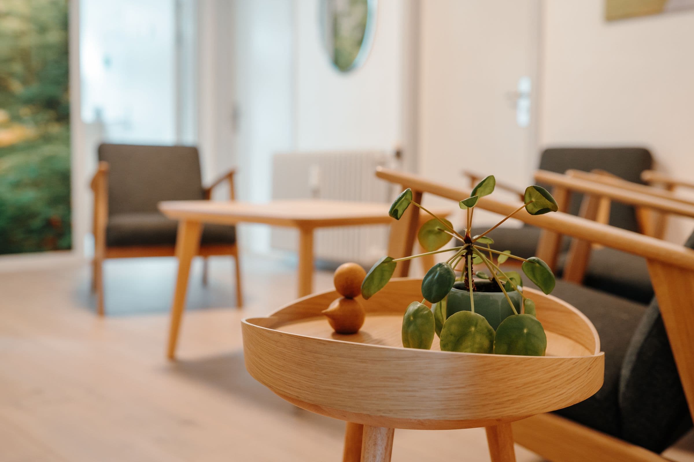 Rundt sofabord i lyst træ med en plante