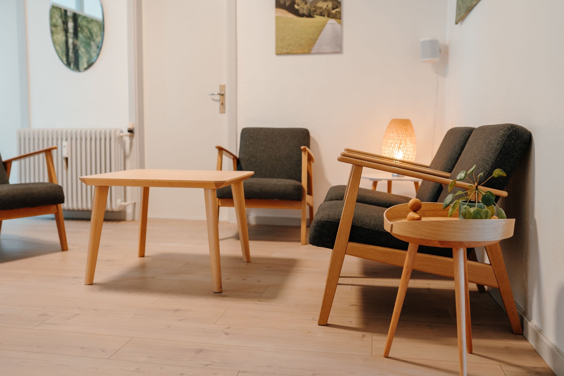 Samtalerum i klinikken med lænestole, sofabord og en tændt lampe